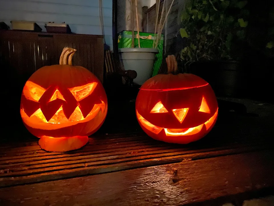 Halloween 2026 Là Ngày Nào? Ý Tưởng Hóa Trang Đơn Giản + Trend Biến Hình Đang Hot 4 Hai quả bí ngô khắc mặt cười phát sáng trong đêm Halloween